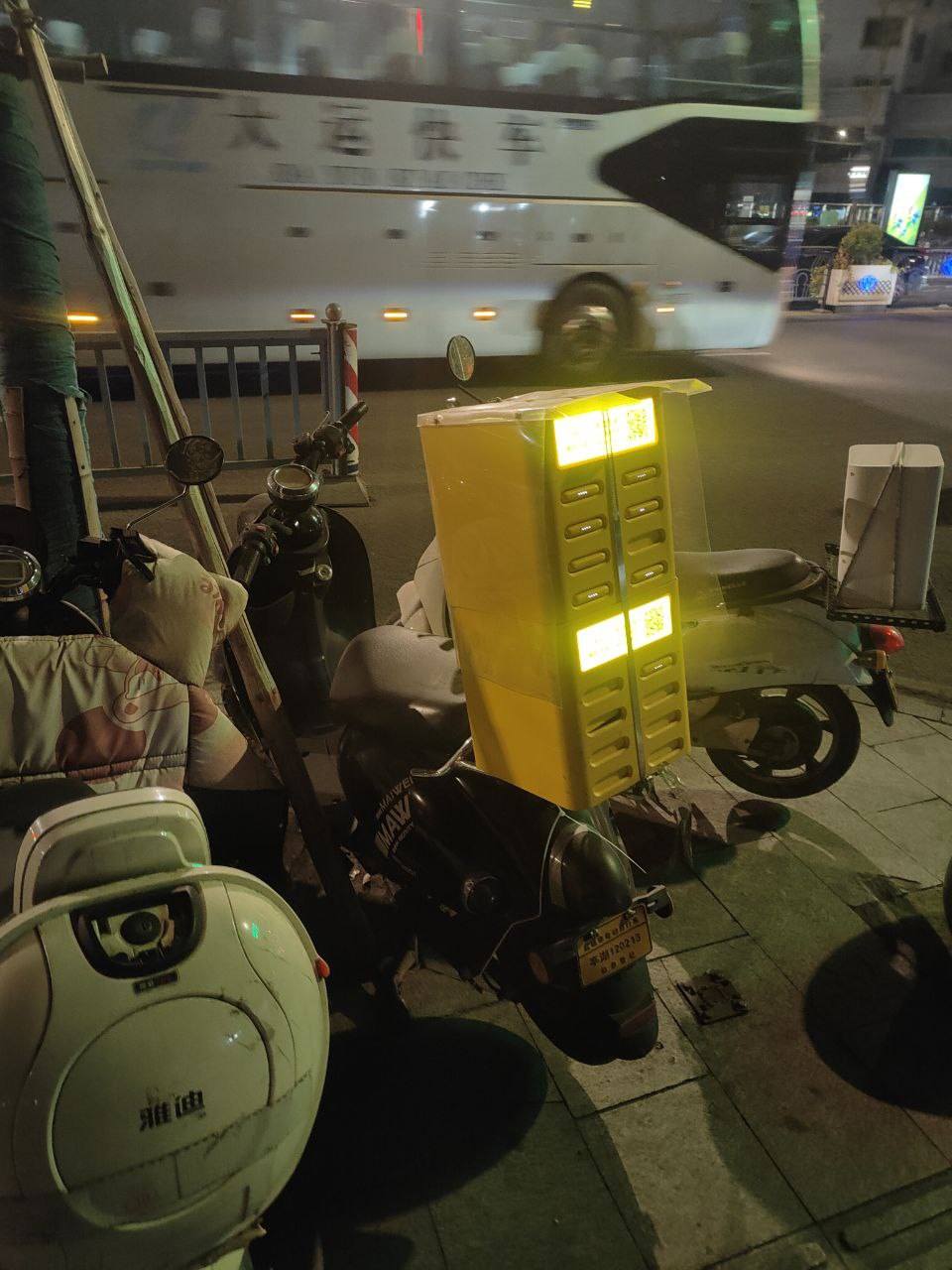 A motorbike carrying a portable battery pack station.