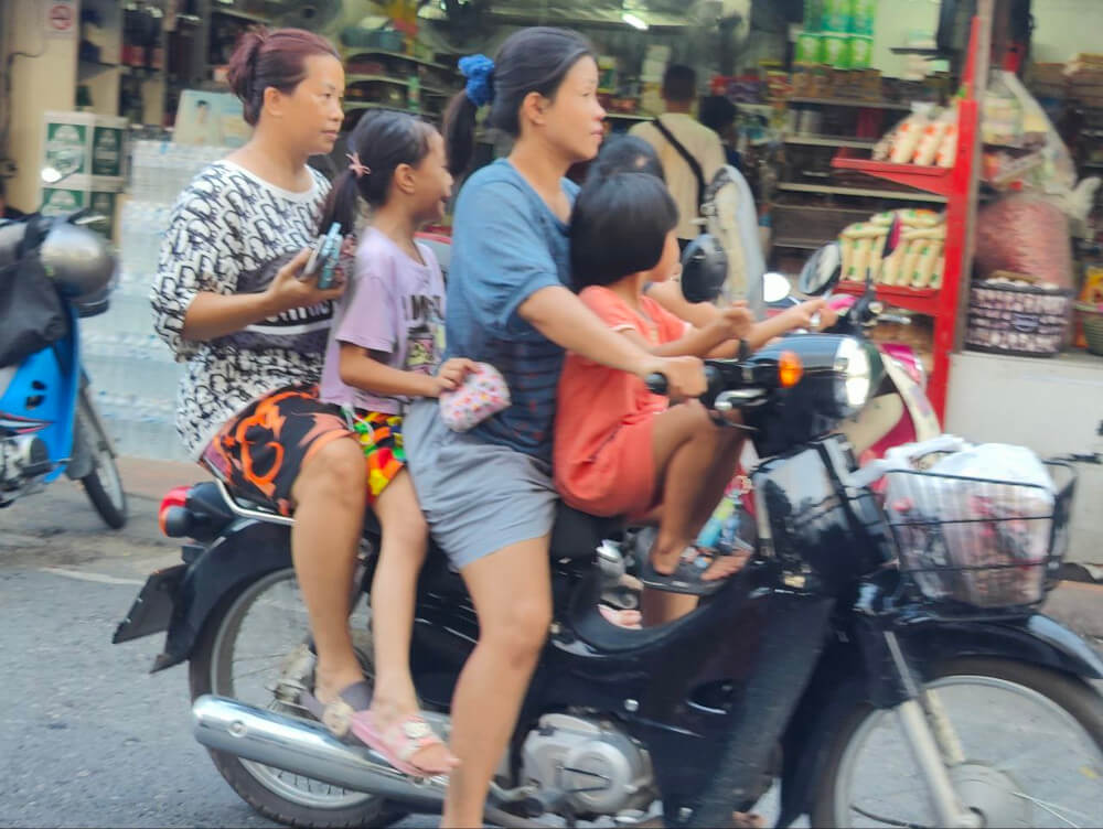 4 people riding on a motorcycle (2 kids, 2 adults)