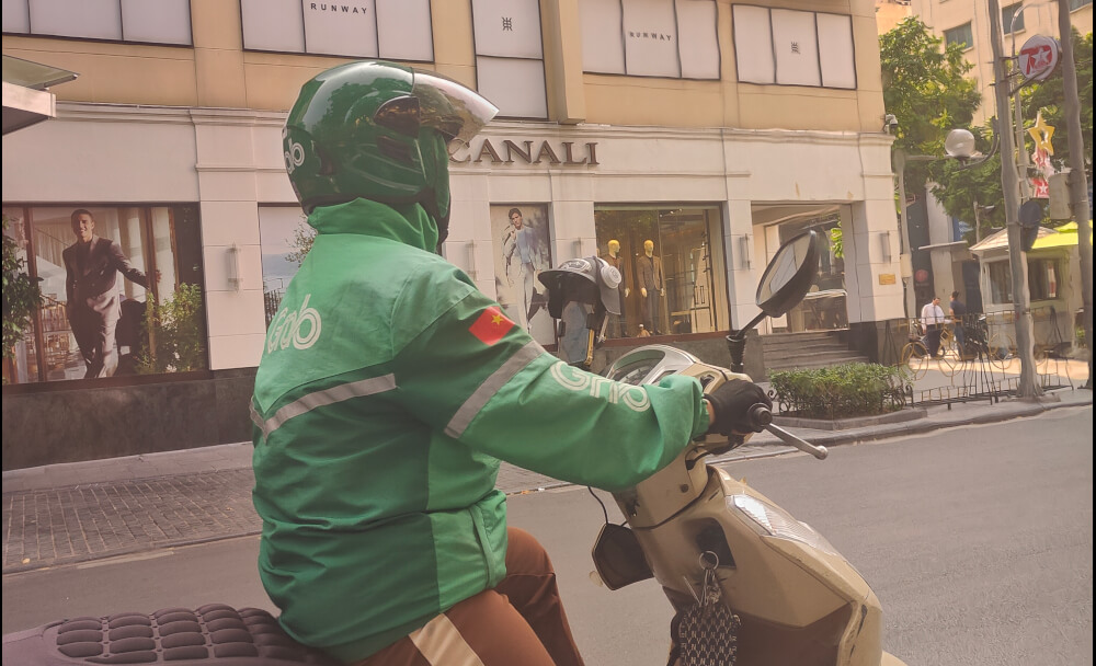 A motorbike with a phone stand that has a mini-helmet.